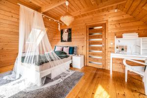1 dormitorio con 1 cama en una cabaña de madera en Villa Carmen, en Korzkiew