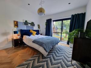a bedroom with a bed and a large window at Bright spacious apartment in the park in London