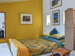 um quarto com paredes amarelas, uma cama e uma mesa em Secret Spot em Newton
