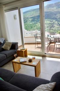 Sala de estar con mesa y 2 copas de vino en Guejar Sierra House with Spectacular Views, en Güéjar-Sierra