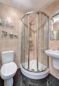 a bathroom with a shower and a toilet and a sink at The Downs, Babbacombe in Torquay