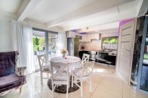 a kitchen and dining room with a table and chairs at Całoroczny dom na Mazurach WrzoSPA z jacuzzi in Stare Juchy