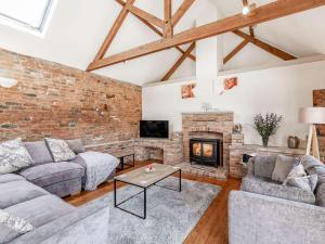 a living room with a brick wall and a fireplace at The Hemmels in Brinkhill