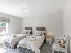 1 dormitorio con 2 camas individuales y 1 silla en The Hemmels en Brinkhill