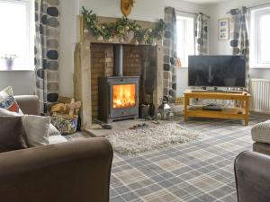 a living room with a fireplace and a tv at Hornby Cottage in Saint Michaels on Wyre