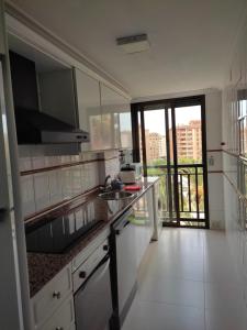 uma cozinha com um lavatório e uma grande janela em Apartamento con balcón cerca del centro em Castellón de la Plana