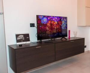 a flat screen tv sitting on top of a dresser at A casa di Ivy e Baby in Turin