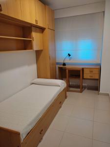 um pequeno quarto com uma cama e uma secretária em Apartamento con balcón cerca del centro em Castellón de la Plana