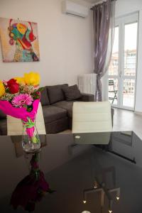 una sala de estar con un jarrón de flores sobre una mesa en A casa di Ivy e Baby, en Turín