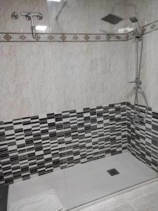 eine Dusche mit schwarzen und weißen Fliesen in der Unterkunft Apartamento con balcón cerca del centro in Castellón de la Plana