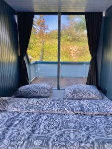 a bed in a room with a large window at Houseboat - best place in Prague in Prague