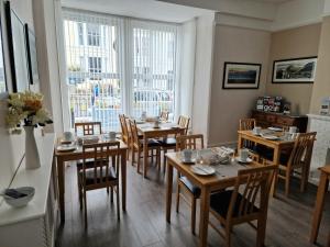 a dining room with tables and chairs and a window at Breeze B&B in Llandudno +47 photos
