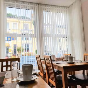 uma sala de jantar com uma mesa e uma grande janela em Breeze B&B em Llandudno