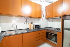 a kitchen with wooden cabinets and a sink and a stove at THE LEMON TREE in Lisbon