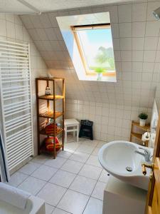 a bathroom with a sink and a skylight at Hedwig meine Perle in Hedwigenkoog