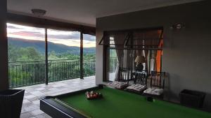 a room with a pool table in front of a balcony at 113 Zwartkloof Private Game Reserve Bela-Bela in Bela-Bela
