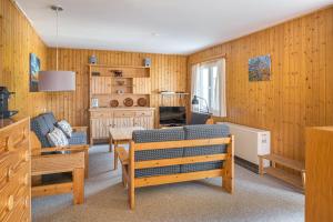 a living room with wood paneled walls and benches at Lotus UG in Fiesch