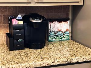 a coffee maker sitting on a counter in a kitchen at Cool & Comfy Condo! Family Friendly! in College Station