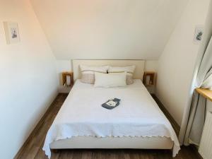 Un pequeño dormitorio con una cama blanca en una habitación en Hedwig meine Perle, en Hedwigenkoog