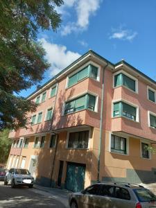 un edificio de ladrillo con coches estacionados frente a él en Loft Carrión en Carrión de los Condes