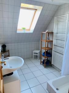 a white bathroom with a sink and a window at Hedwig meine Perle in Hedwigenkoog