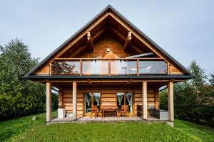 Cabaña de madera con ventana grande y comedor en Villa Carmen, en Korzkiew