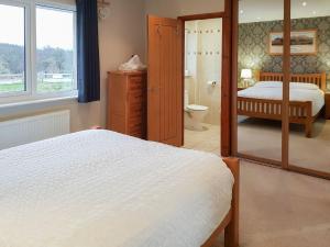een slaapkamer met een bed en een spiegel bij Cuiltean in Gairlochy