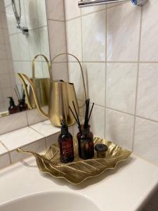 a bathroom sink with two candles on a gold tray at Eurenerstrasse 179 Tourist Apartments in Trier
