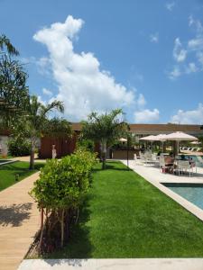 un complexe avec une piscine et de l'herbe verte dans l'établissement Flat Île de Pipa Resort - Centro, à Pipa