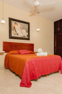 ein Schlafzimmer mit einem Bett mit einer roten Decke in der Unterkunft Hotel Nojoch che in Cobá