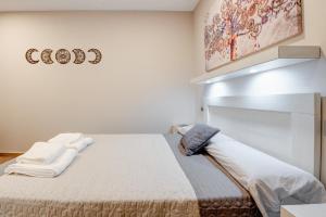 a bedroom with a large bed with towels on it at Apartamentos Menorá in Toledo