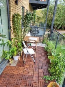 a patio with plants and a table on a balcony at Bright spacious apartment in the park in London