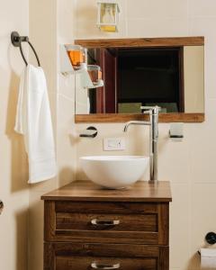 ein Badezimmer mit einem weißen Waschbecken und einem Spiegel in der Unterkunft Hotel Nojoch che in Cobá