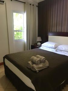 1 dormitorio con 1 cama con toallas en Ocio Apart en Puerto Iguazú