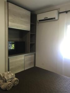 a living room with a tv and a wall at Ocio Apart in Puerto Iguazú
