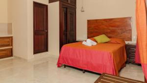 Schlafzimmer mit einem Bett und einem Kopfteil aus Holz in der Unterkunft Hotel Nojoch che in Cobá
