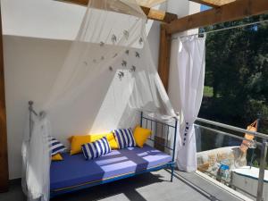 a porch with a blue couch on a balcony at Ínsua Hostel in São Pedro do Sul