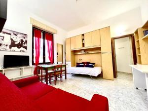 un salon avec un canapé rouge et une chambre dans l'établissement Kibilù - Via Colonna con parcheggio vicinanze Ospedale di Circolo, à Varèse