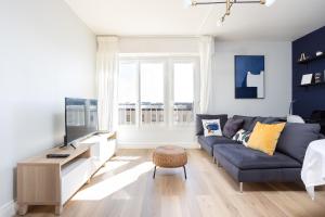 a living room with a blue couch and a tv at Renovated apartment metro, parking included, near Porte Versaille in Vanves