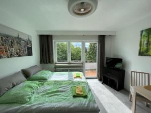 una camera da letto con un grande letto verde e una televisione di Ruhiges und klimatisiertes Apartment a Stoccarda