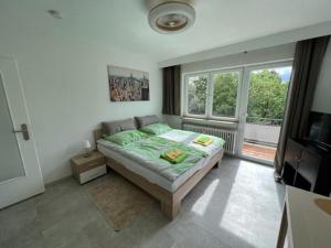 une chambre avec un lit et une grande fenêtre dans l'établissement Ruhiges und klimatisiertes Apartment, à Stuttgart