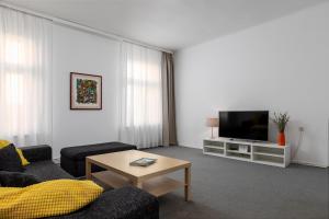 ein Wohnzimmer mit einem Sofa und einem TV in der Unterkunft Zagreb City Apartments in Zagreb