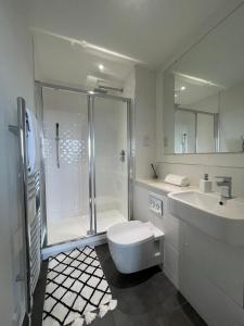 a bathroom with a shower and a toilet and a sink at Premier Suite- Bedford city centre with free gym & parking in Bedford