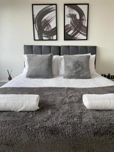 a bedroom with a large bed with two pillows at Premier Suite- Bedford city centre with free gym & parking in Bedford
