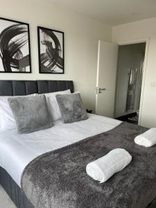 a bedroom with a large bed with two pillows on it at Premier Suite- Bedford city centre with free gym & parking in Bedford