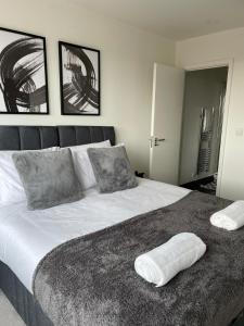 ein Schlafzimmer mit einem großen Bett mit zwei Kissen darauf in der Unterkunft Premier Suite- Bedford city centre with free gym & parking in Bedford + 1 Foto