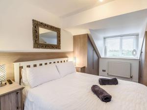 a bedroom with a large white bed and a mirror at The Paddocks in Ault Hucknall