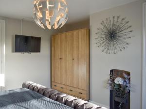 a living room with a couch and a chandelier at Cernunnos Cottage in Leven