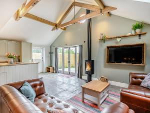 a living room with a couch and a tv at The Old Stables - Uk38576 in Aston Cantlow