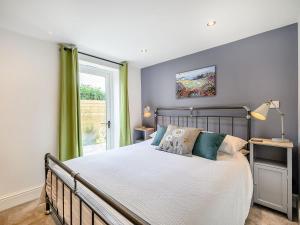 Un dormitorio con una cama grande y una ventana en The Old Stables - Uk38576 en Aston Cantlow